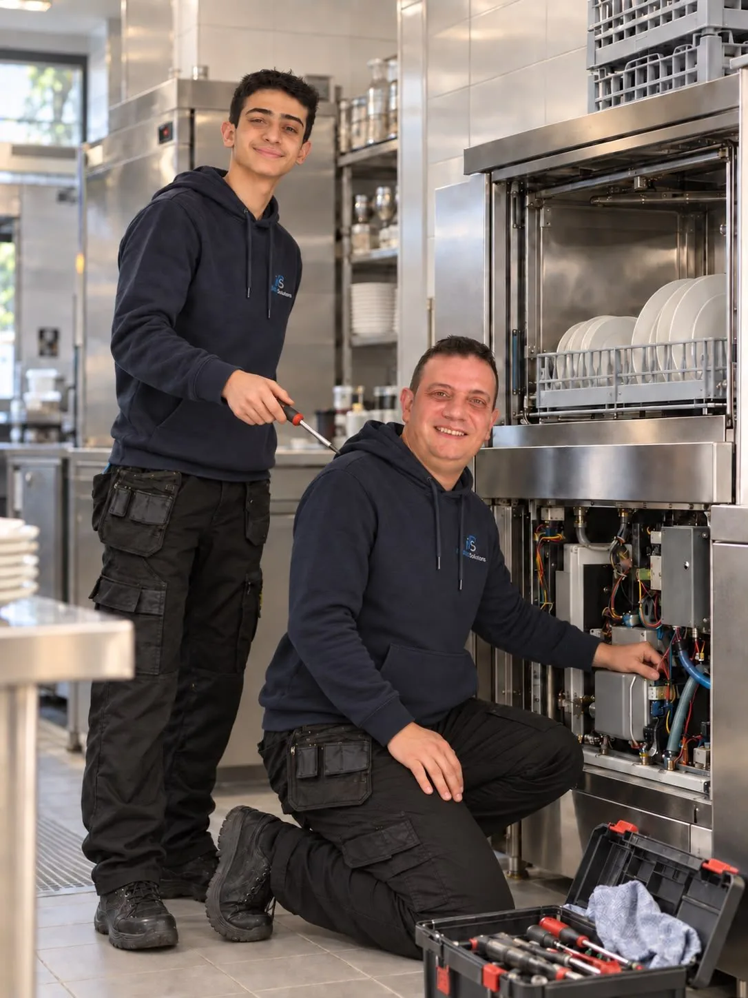 Twee techniekers van Protech Solutions herstellen een professionele vaatwasser